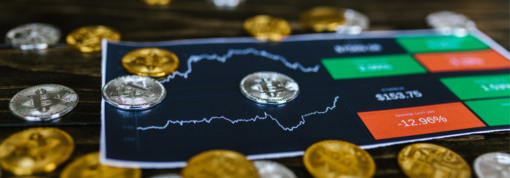 a picture of coins sitting on top of a screen with charts of daily gold and silver pricing