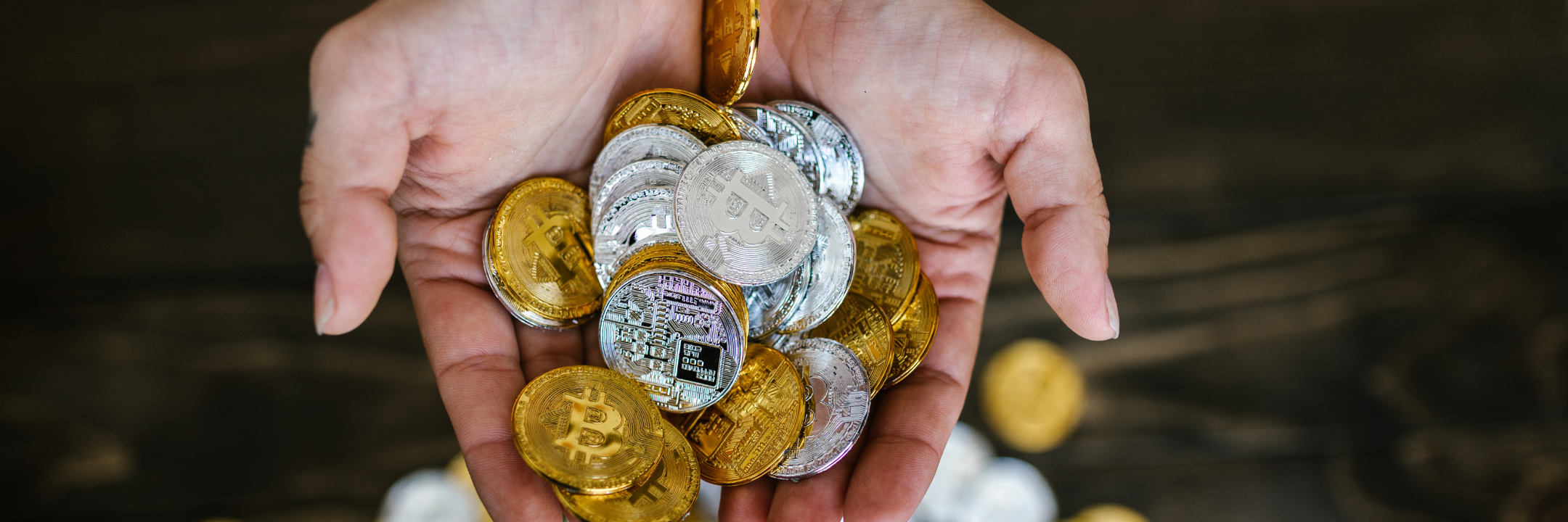 two hands holding gold and silver coins